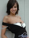 Dark haired playful girl with charming smile flirtatiously flashes her tits