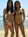 Two sexy oriental babes turn around showing their tits and booties on the beach