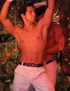 Two sexy gay strippers dressed in white go topless on stage at Canadian strip ba