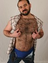 Bearded gay bear Gabe Harris strips nude to show his hairy chest, back and cock