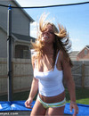 Long haired chick in tight green panties has fun jumping in the backyard