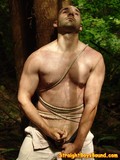 Straight man gets tied to a tree in the forest and strokes his cock for kinky guy's viewing pleasure