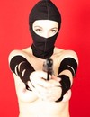 Lady in black mask poses with gun and humiliates naked man on the floor