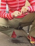 Curly haired redhead is secretly filmed when peeing in her pants just in the street