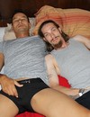 Gay friends in black briefs touch their dicks side by side on the bed before they get it started