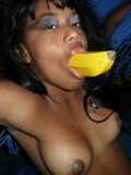 Ebony lesbian girlfriends with shaved pussies and natural tits share a banana